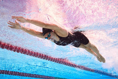 Amanzi Women's Acceler8 RIZE Kneesuit in Jet and Spearmint, showcasing a sleek wetsuit with long sleeves and fitted design.