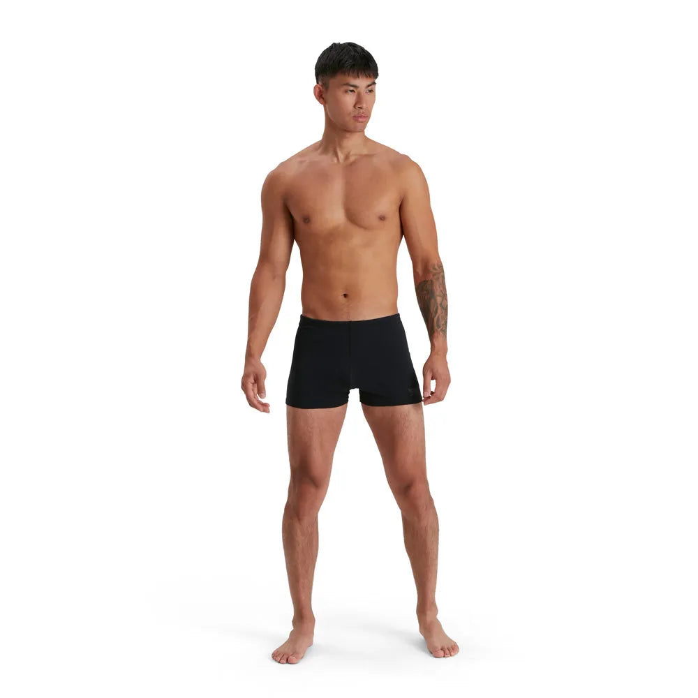 Black Speedo men's Eco Endurance+ aquashorts, close-up view showing the stretchy fabric and snug fit for swimming.