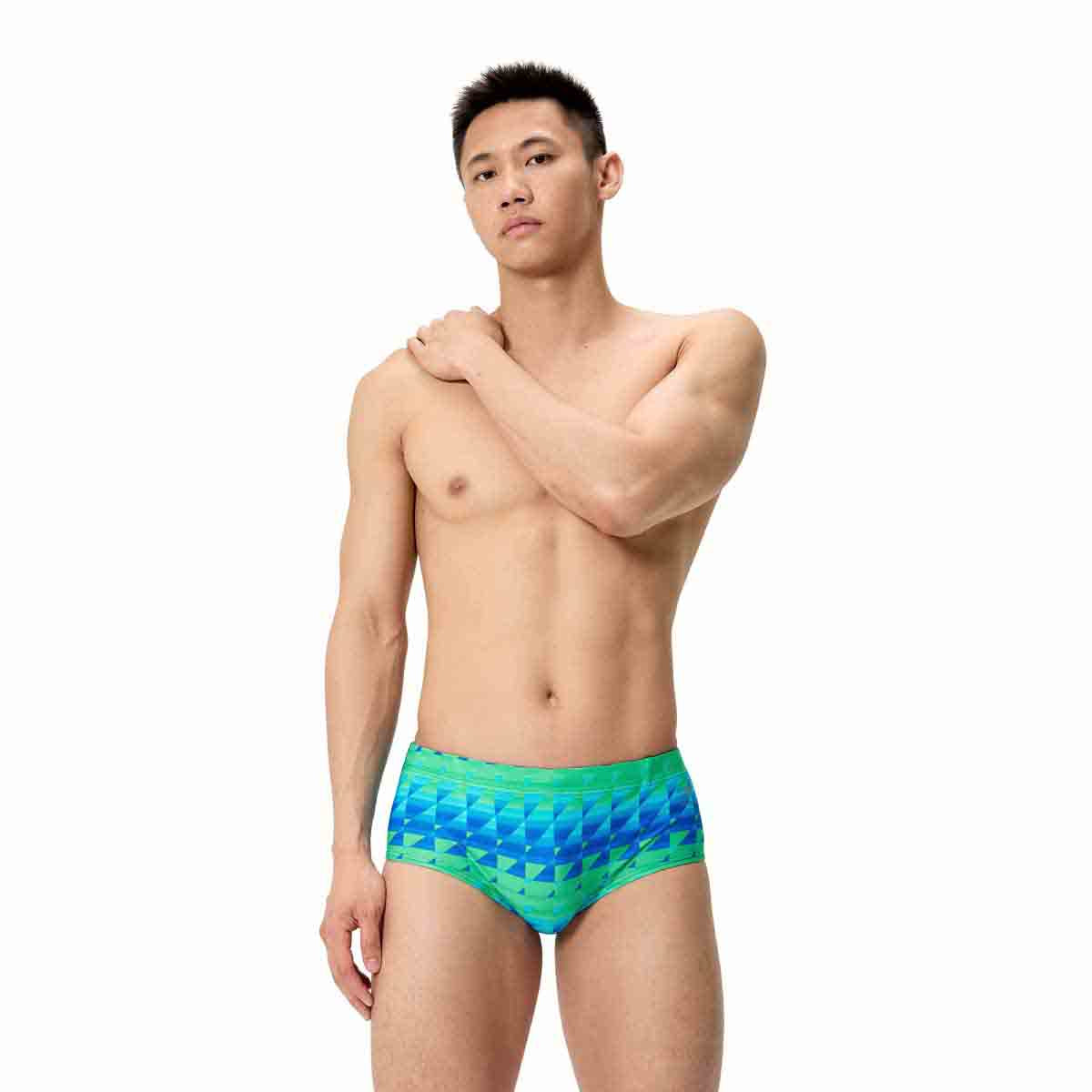 Speedo men's printed 13.5cm brief featuring quilt triangle design in blue and green, made from quick-drying swimwear fabric.
