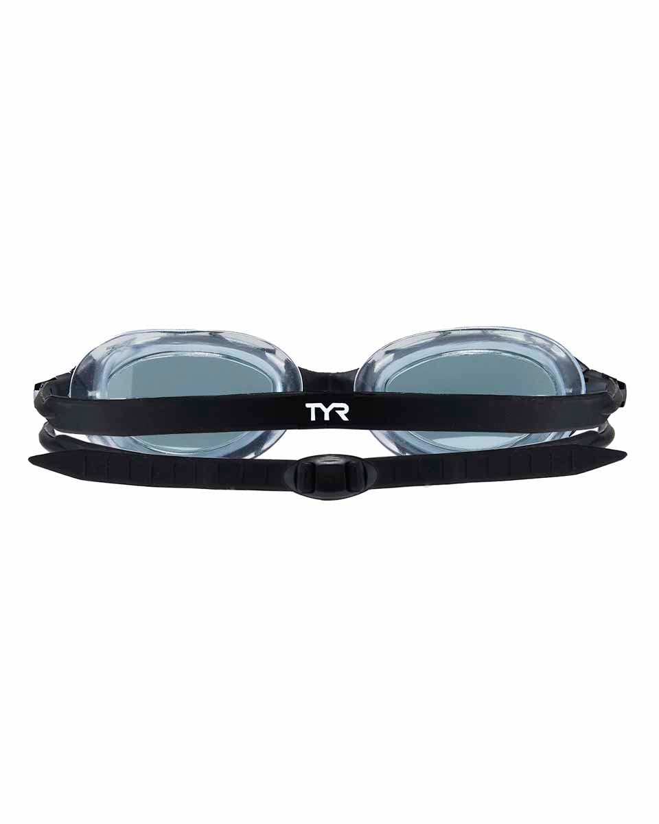 TYR Nest Pro swimming goggles in smoke color, with adjustable straps and clear lenses, designed for competitive swimming.