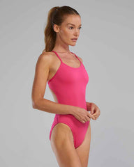 TYR women's solid cutout swimsuit in vibrant fuchsia, featuring sleek design and stylish cutouts for active swimming and beach wear.