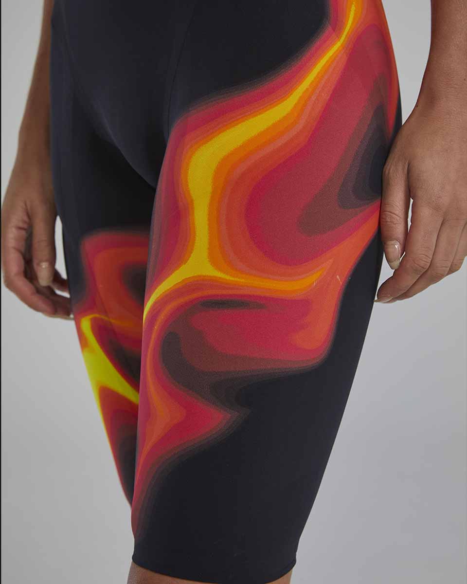 TYR Women's Venzo Infrared open back kneeskin suit in fire red, showing the sleek swimwear design with open back and vibrant color.