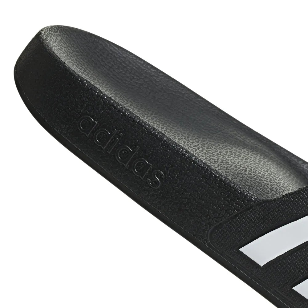 Black Adidas Adilette Aqua Slides on a flat surface, showing the sporty slide sandals with the Adidas logo visible.