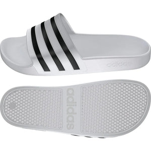 White Adidas Adilette Aqua slides on a tiled surface, showcasing comfortable slip-on design and sporty style.
