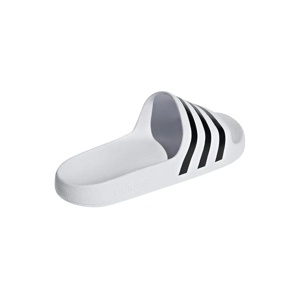 White Adidas Adilette Aqua Slides on a model's feet, showcasing comfortable slip-on design and sporty style.