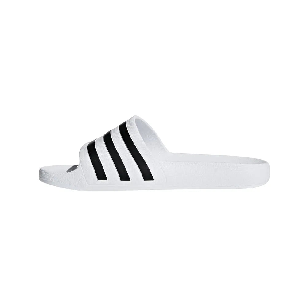 White Adidas Adilette Aqua Slides worn with sports socks, casual footwear for poolside or beach activities.