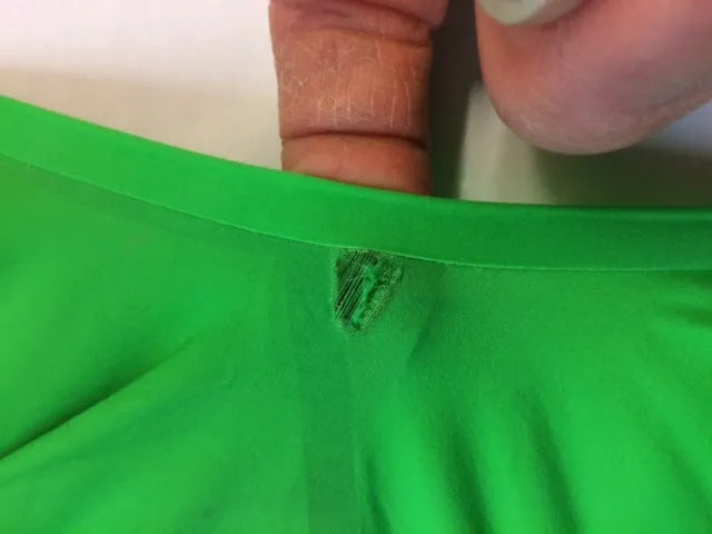AK race suit repair service, showing a close-up of a race suit with professional patching and stitching for quick turnaround.