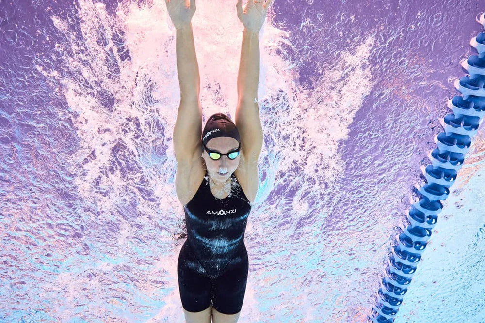 Amani Women's Acceler8 RIZE Kneesuit in Jet and Spearmint colors, showing a sleek, form-fitting wetsuit for women.