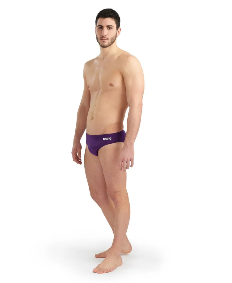 Arena men's solid team swim briefs in plum and white, featuring a snug fit and durable fabric for competitive swimming.