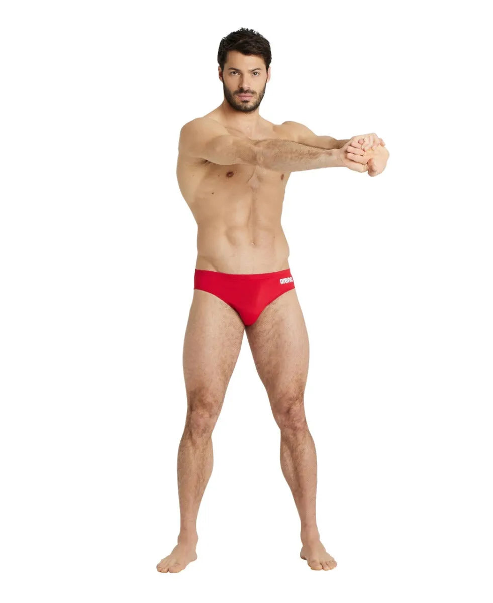 Arena men's team swim solid briefs in blue, close-up view showing the snug, elastic waistband and sleek swimwear fabric.