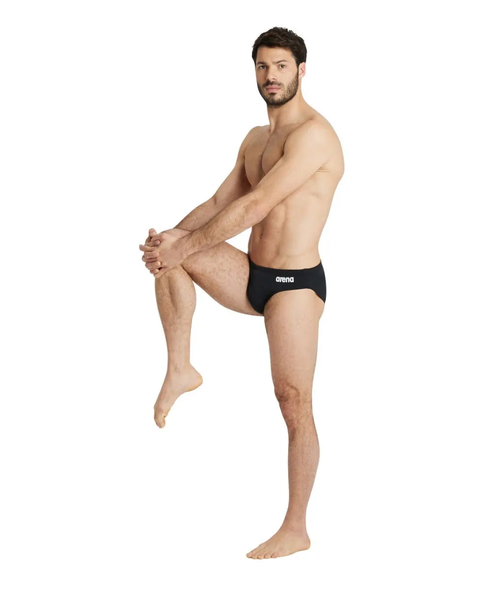 Black Arena men's team swim briefs, snug fit, with the brand logo visible, designed for competitive swimming.