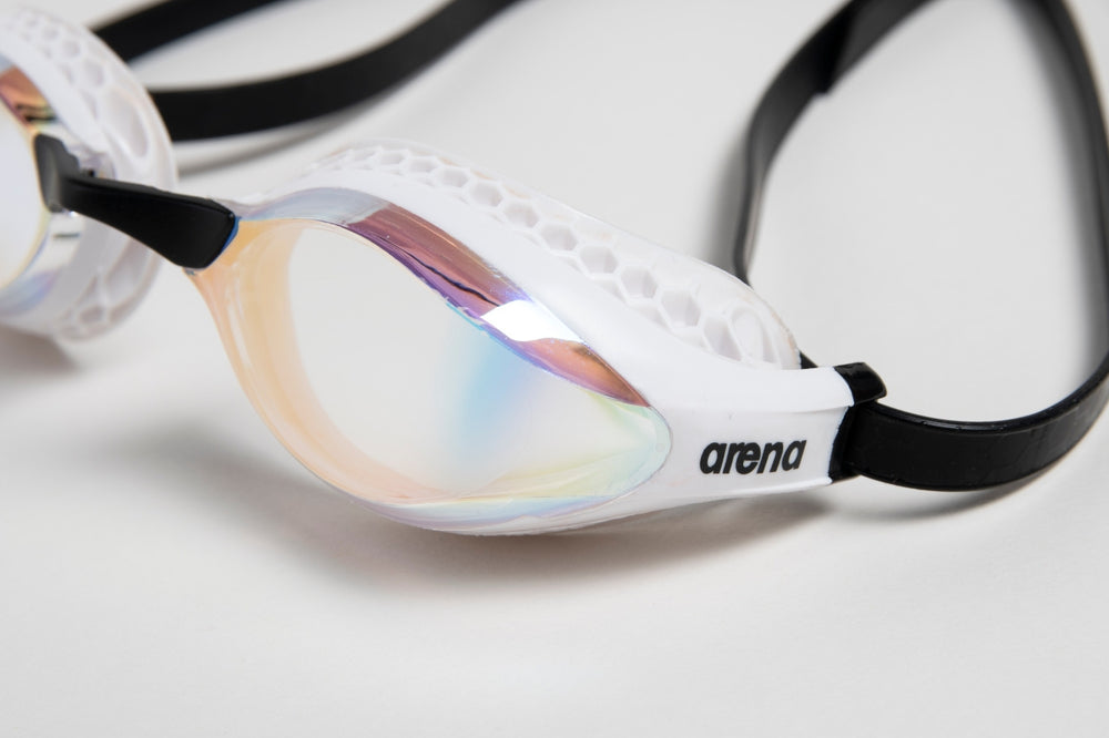 Arena Airspeed Mirror goggles in white and copper with reflective lenses, designed for competitive swimmers.