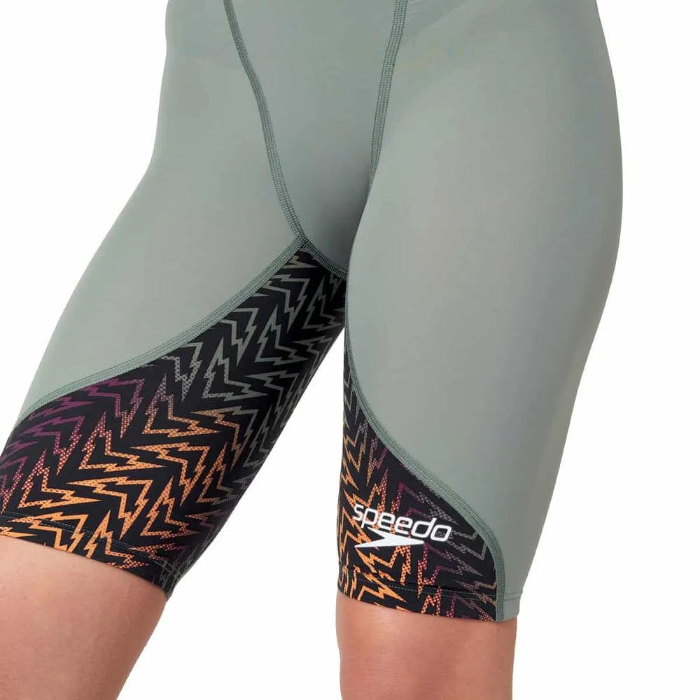 Speedo Women's Fastskin LZR Ignite kneesuit in green and orange, showcasing a sleek, form-fitting design for competitive swimming.