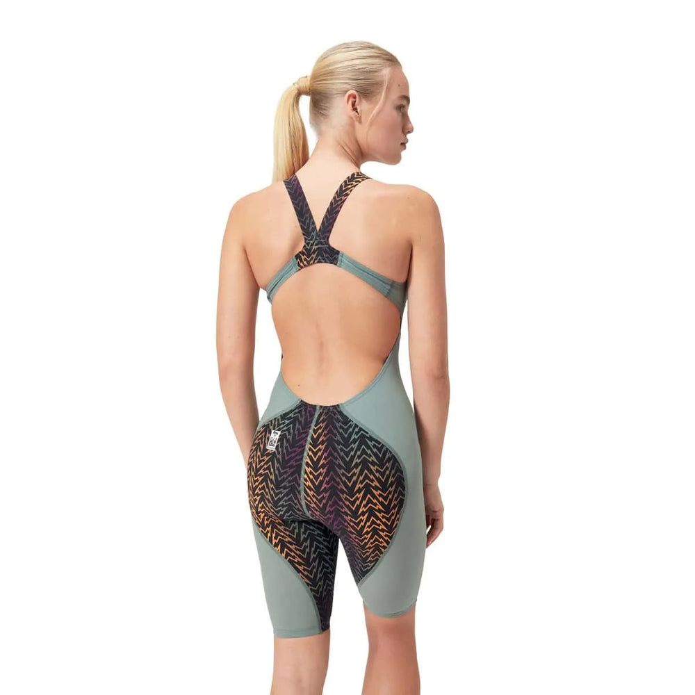 Speedo Women's Fastskin LZR Ignite Kneeskin in green and orange, close-up showing sleek, form-fitting swimwear for competitive swimming.